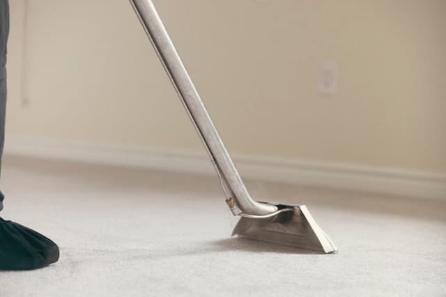 Hot-water extraction wand cleaning a carpet